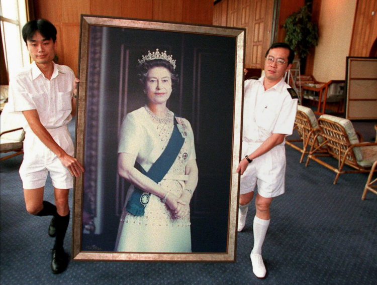 A portrait of Britain's Queen Elizabeth is removed from the wall at the HMS Tamar, the 'British Forces' Hong Kong headquarters, on June 16, 1997, ahead of the handover on July 1. Photo: AFP